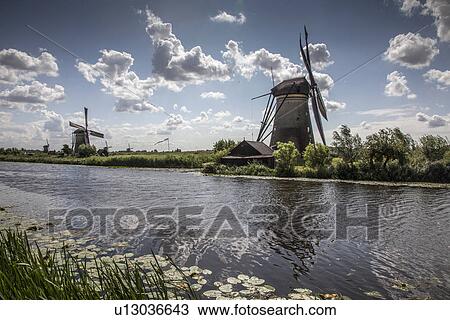 Stock Image - Windmills and canal, Kinderdijk, Netherlands. Fotosearch