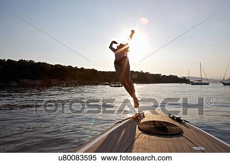 Stock Photography - Woman diving from boat, Cannes Islands, Cote D'Azur, France. Fotosearch