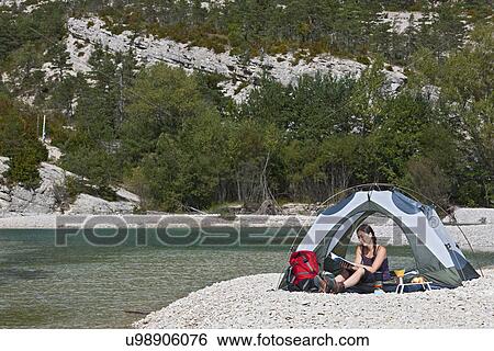 Stock Photograph - Woman in tent by river, Canyon du Verdon, Provence, France. Fotosearch