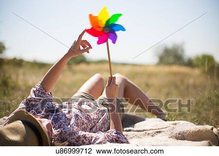 Woman lying in on back holding windmill View Large Photo Image Stock Image - Woman lying in on back holding windmill. Fotosearch