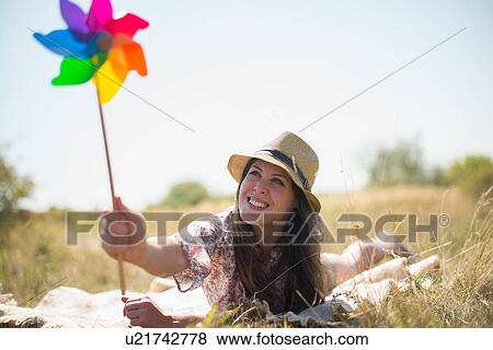 Woman lying in on front holding windmill View Large Photo Image Stock Photo - Woman lying in on front holding windmill. Fotosearch