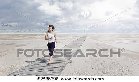 Woman running on boardwalk, Sankt Peter Ordings, Schleswig Holstein, Germany View Large Photo Image Stock Photograph - Woman running on boardwalk, Sankt Peter Ordings, Schleswig Holstein, Germany. Fotosearch