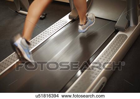 Picture - Woman running on treadmill. Fotosearch