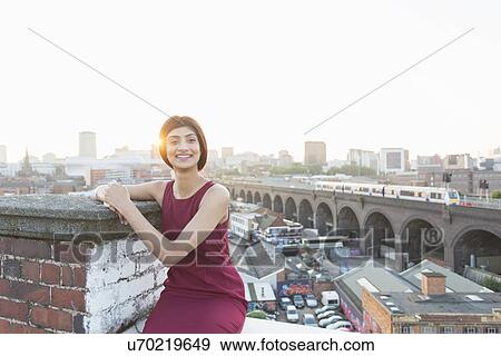 Woman sitting on rooftop, Birmingham, England, UK View Large Photo Image Stock Photo - Woman sitting on rooftop, Birmingham, England, UK. Fotosearch