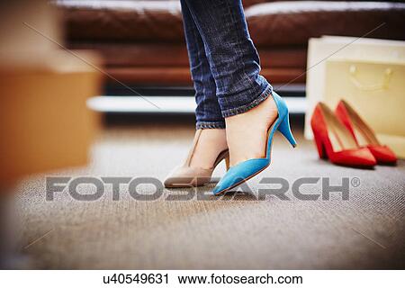 Stock Image - Woman trying on high heeled shoes. Fotosearch