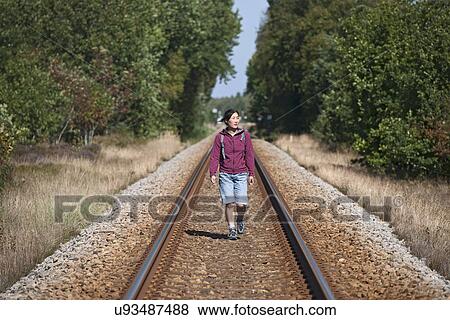 Woman walking along railtrack, Skagen, Denmark View Large Photo Image Stock Photo - Woman walking along railtrack, Skagen, Denmark. Fotosearch