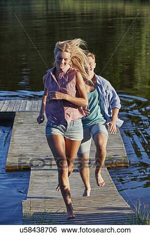 Young adult couple running on pier, Gavle, Sweden View Large Photo Image Stock Photograph - Young adult couple running on pier, Gavle, Sweden. Fotosearch