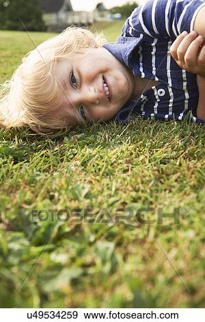 Stock Photo - Young boy playing in garden. Fotosearch