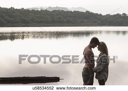 Young couple by lake, Cumbria, England, UK View Large Photo Image Stock Image - Young couple by lake, Cumbria, England, UK. Fotosearch