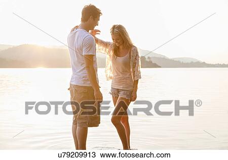 Young couple by lake, Cumbria, England, UK View Large Photo Image Stock Image - Young couple by lake, Cumbria, England, UK. Fotosearch