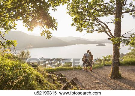 Young couple by lake, Cumbria, England, UK View Large Photo Image Stock Photography - Young couple by lake, Cumbria, England, UK. Fotosearch