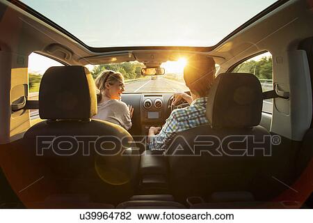 Stock Image - Young couple driving in car. Fotosearch