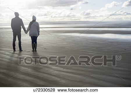 Young couple holding hands, Brean Sands, Somerset, England View Large Photo Image Stock Photo - Young couple holding hands, Brean Sands, Somerset, England. Fotosearch