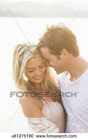Stock Image - Young couple hugging, laughing. Fotosearch