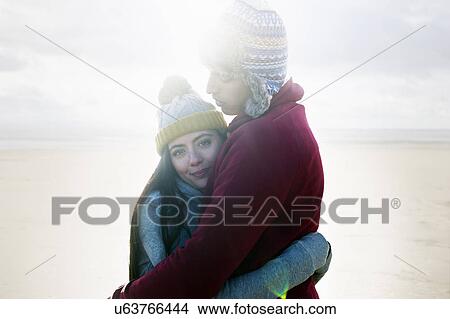 Picture - Young couple hugging on beach. Fotosearch