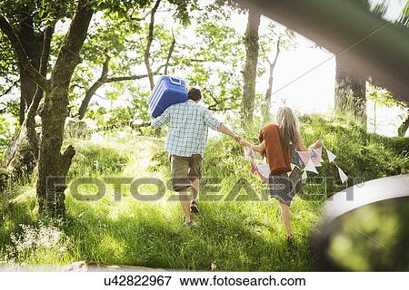 Young couple in forest with bunting and cool box View Large Photo Image Stock Photo - Young couple in forest with bunting and cool box. Fotosearch