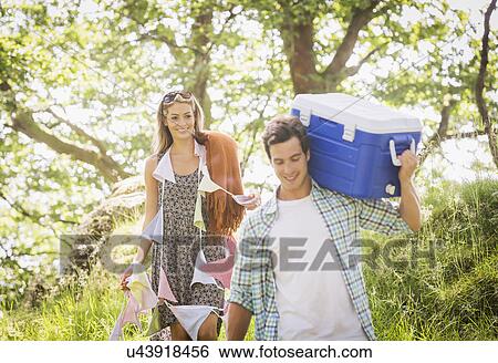 Stock Photograph - Young couple in forest with bunting and cool box. Fotosearch