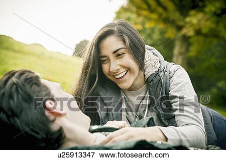Young couple in park, laughing View Large Photo Image Stock Photo - Young couple in park, laughing. Fotosearch