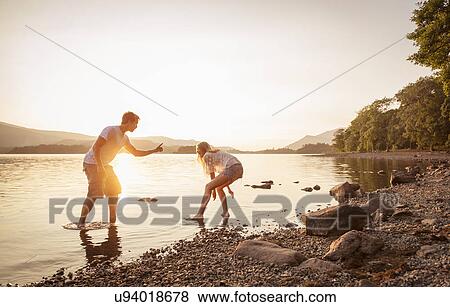 Young couple paddling in lake, Cumbria, England, UK View Large Photo Image Stock Photo - Young couple paddling in lake, Cumbria, England, UK. Fotosearch