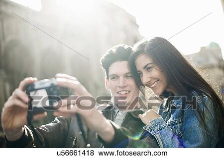 Young couple photographing themselves View Large Photo Image Stock Photo - Young couple photographing themselves. Fotosearch