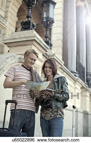 Stock Photograph - Young couple reading map, Cape Town, South Africa. Fotosearch