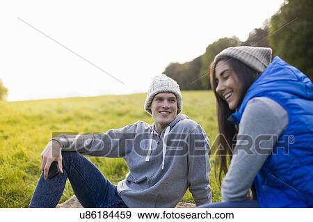 Young couple sitting on grass laughing View Large Photo Image Stock Photo - Young couple sitting on grass laughing. Fotosearch