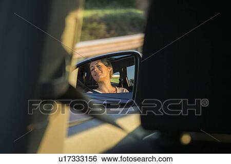 Young female passenger reflected in wing mirror View Large Photo Image Stock Photograph - Young female passenger reflected in wing mirror. Fotosearch