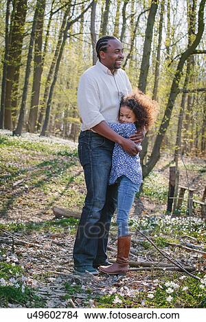 Young girl and father hugging in woods View Large Photo Image Picture - Young girl and father hugging in woods. Fotosearch