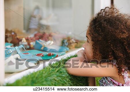 Young girl looking through shoe shop window View Large Photo Image Picture - Young girl looking through shoe shop window. Fotosearch