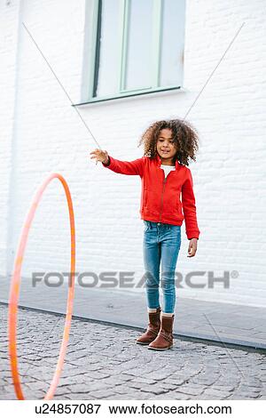 Young girl playing with hoola hoop View Large Photo Image Stock Photo - Young girl playing with hoola hoop. Fotosearch