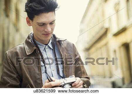 Stock Photo - Young man holding camera. Fotosearch