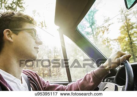 Young man leaning driving convertible on country road View Large Photo Image Stock Photo - Young man leaning driving convertible on country road. Fotosearch