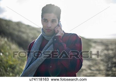 Stock Image - Young man using smartphone. Fotosearch