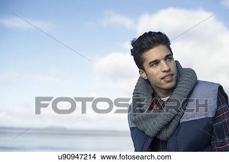 Young man wearing grey scarf View Large Photo Image Picture - Young man wearing grey scarf. Fotosearch