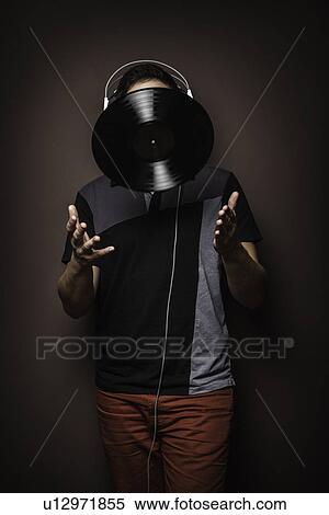Young man wearing headphones throwing vinyl record View Large Photo Image Stock Photography - Young man wearing headphones throwing vinyl record. Fotosearch