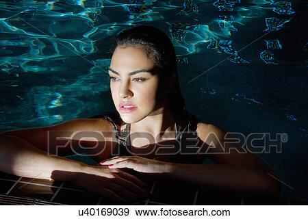 Stock Photo - Young woman gazing from spa swimming pool. Fotosearch