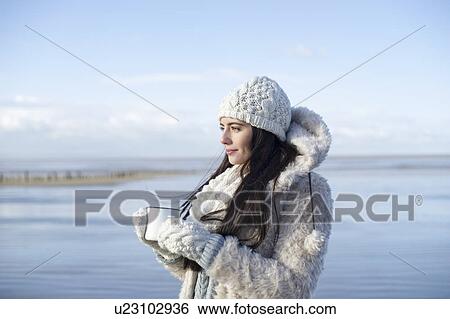 Young woman holding coffee on beach, Brean Sands, Somerset, England View Large Photo Image Stock Photograph - Young woman holding coffee on beach, Brean Sands, Somerset, England. Fotosearch