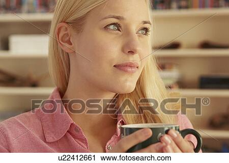 Young woman holding hot drink View Large Photo Image Stock Image - Young woman holding hot drink. Fotosearch