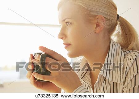 Young woman holding hot drink View Large Photo Image Stock Photography - Young woman holding hot drink. Fotosearch