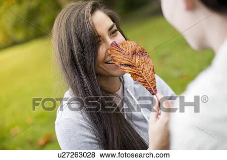 Stock Photo - Young woman holding leaf. Fotosearch