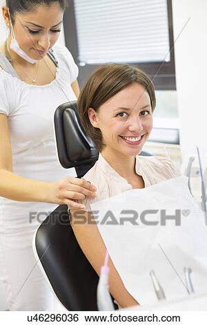 Young woman in dentists chair with dental nurse View Large Photo Image Stock Photograph - Young woman in dentists chair with dental nurse. Fotosearch
