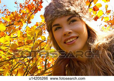 Young woman in fur hat in autumnal park View Large Photo Image Stock Photograph - Young woman in fur hat in autumnal park. Fotosearch