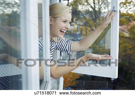 Young woman leaning out of window View Large Photo Image Stock Image - Young woman leaning out of window. Fotosearch