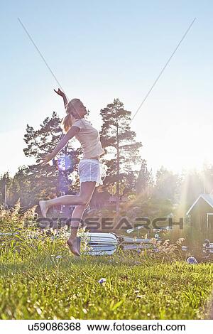 Young woman leaping next to lake, Gavle, Sweden View Large Photo Image Stock Photo - Young woman leaping next to lake, Gavle, Sweden. Fotosearch