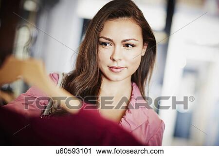 Young woman looking pink top on hanger View Large Photo Image Stock Image - Young woman looking pink top on hanger. Fotosearch