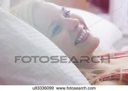 Young woman lying in bed View Large Photo Image Stock Photo - Young woman lying in bed. Fotosearch