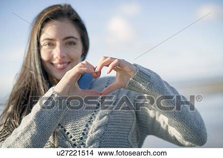 Young woman making heart shape with hands View Large Photo Image Picture - Young woman making heart shape with hands. Fotosearch