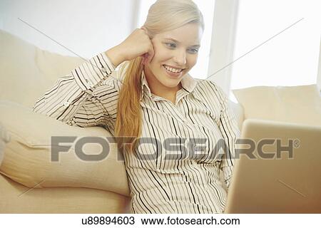 Young woman on sofa, using digital tablet View Large Photo Image Stock Image - Young woman on sofa, using digital tablet. Fotosearch