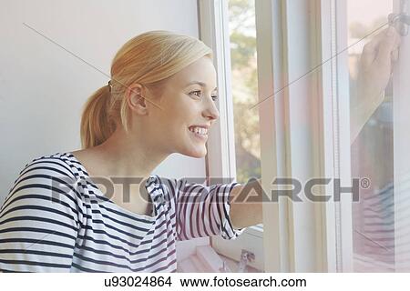 Young woman opening window View Large Photo Image Picture - Young woman opening window. Fotosearch