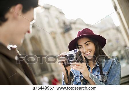 Stock Photo - Young woman photographing man. Fotosearch